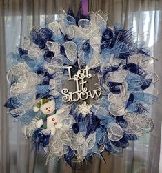 a blue and white mesh wreath with a snowman on it