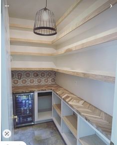 an empty room with shelves, cabinets and a birdcage hanging from the ceiling