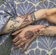 two people with tattoos on their arms and hands, one holding the other's hand