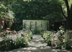 an outdoor garden with lots of flowers and chairs