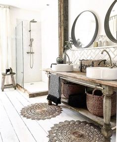 a bathroom with two sinks, mirrors and rugs on the floor in front of it