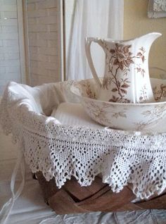 a white pitcher sitting on top of a wooden tray next to a lace doily