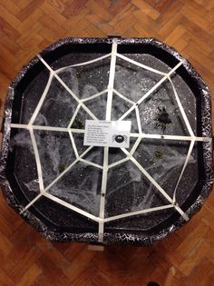 a table that has some kind of spider web on it, and is sitting on the floor