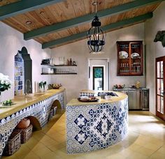 a kitchen with blue and white tiles on the counter tops, an island in the middle