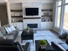 a living room filled with furniture and a flat screen tv mounted on the wall above a fireplace