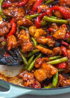 chicken and vegetables are being cooked in a skillet