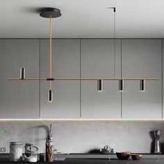 a modern kitchen with grey cabinets and black counter tops, hanging lights above the sink