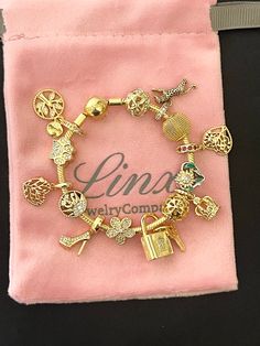 Linx smooth snake chain style charm bracelet in 14k yellow gold over 925 sterling silver, with a ball clasp.  *Available in multiple sizes. *Additional charms may also be added. *Compatible with all standard size open works charms, including Linx, Pandora and Gnoce. *Bracelet will also come in a velvet, jewelry pouch, making it perfect for gift giving also. *Please add 1 inch to the measurement of your wrist, in order to allow room for your charms, as charms will cause the bracelet to fit a bit tighter. This bracelet includes 14 Linx charms in 14K yellow gold over 925 sterling silver. Luxury Charm Bracelet As Gift, Luxury Charm Bracelet For Gift, Gold Charm Bracelet With Removable Charms For Gift, Gold Charm Bracelet With Removable Charms As Gift, Elegant Charm Bracelet With Removable Charms As Gift, Elegant Gold Charms With Dangling Details, Gold Bracelet With Charms As A Gift, Gold-plated Charm Bracelet, Gold Charm Bracelet As Gift For Her