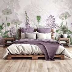 a bed with purple and white flowers on the wall