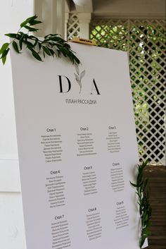 the seating chart for an event is displayed on a large white board with greenery