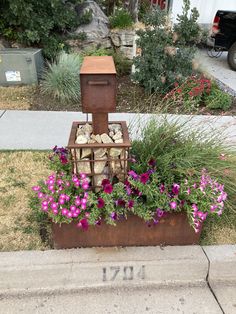 a mailbox with flowers and rocks in it