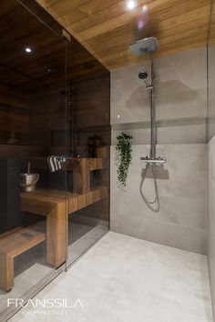 a bathroom with a shower, sink and bench inside of it's glass enclosure