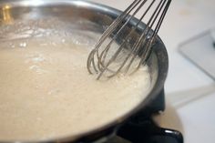 a whisk is being stirred in a pan on the stove