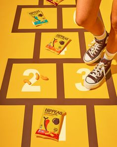 a person standing on top of a yellow floor next to some chips and snacks in front of them