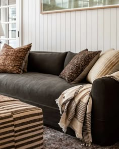 a living room with couches and pillows on the floor