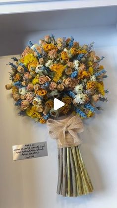 a bouquet of flowers is on display in a white box with a ribbon around it