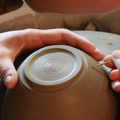 a person that is making something out of clay on a potter's wheel with their hands