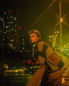 a man standing on the side of a road at night