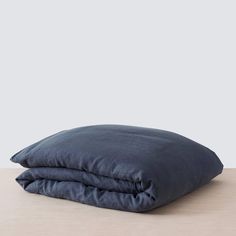 two dark blue pillows sitting on top of a wooden table