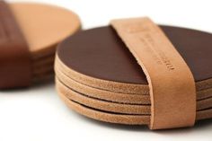 a stack of brown coasters sitting on top of each other with a leather strap