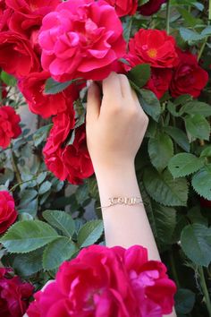 a woman's hand holding onto red flowers with the word love written on it