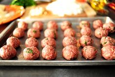 raw meatballs on a baking sheet ready to be cooked in the oven for consumption