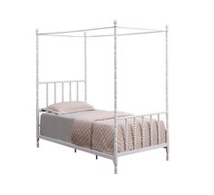 a white metal bed frame with four posts