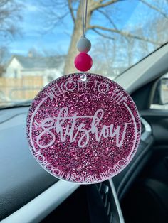 a car dashboard decoration with pink glitter on it