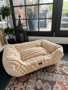 a dog bed sitting on top of a rug