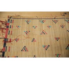 a close up of a piece of cloth on a wooden table with scissors and thread