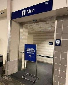 an empty men's restroom with a sign on the door