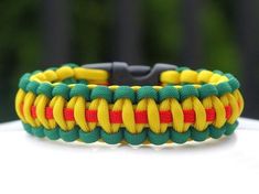 a yellow and green paracorine bracelet on top of a white table with trees in the background