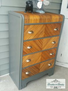 an old dresser has been painted gray and woodgrain with silver hardware on it