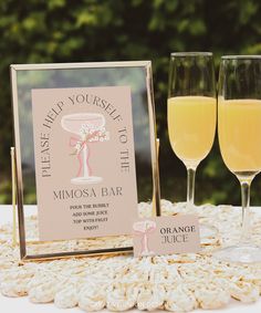 two glasses of orange juice sitting on top of a table next to a sign that says, please help yourself to mimosa bar