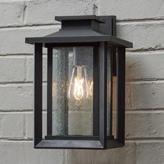 a light that is on the side of a wall next to a white brick building