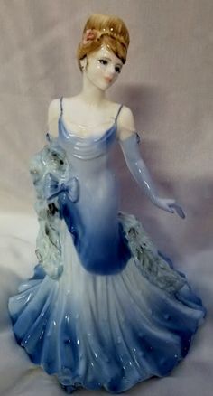 a ceramic figurine of a woman in a blue dress