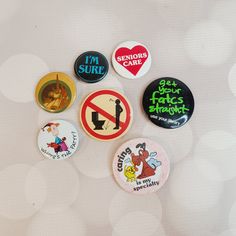 six badges are arranged in a circle on a white surface with blurry boke