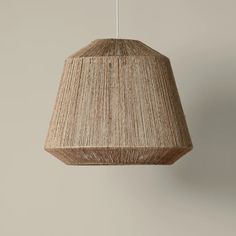 a lamp hanging from a ceiling with a light brown shade on the top and bottom