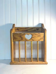 a wooden crib with a heart cut out on the front and sides, against a white wall