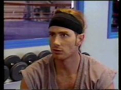 a man with a headband sitting in front of a gym