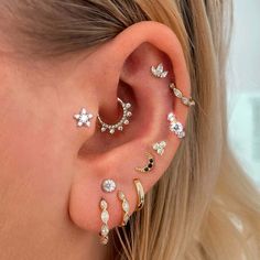 a woman's ear with four different types of piercings