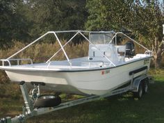 a white boat is parked in the grass