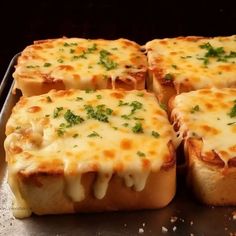 four pieces of bread with cheese and parsley on top