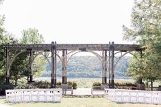 an outdoor ceremony set up with white chairs