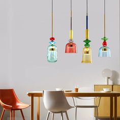 three colorful lights hanging from the ceiling above a dining room table