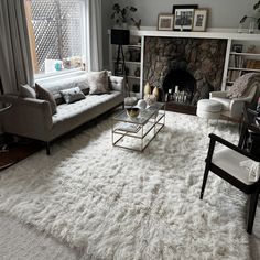 a living room filled with furniture and a fire place in the middle of a room