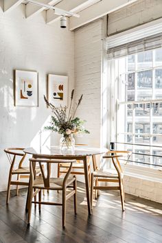 a dining room table and chairs in front of a window