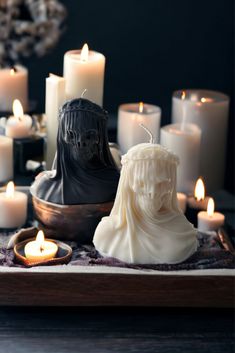 some candles are sitting on a table with a busturine in front of them