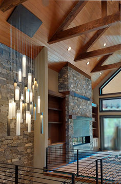 a living room filled with lots of furniture and stone wall mounted fire place next to a fireplace