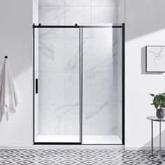 a white and black bathroom with marble tiles on the floor, shower stall door and towel rack